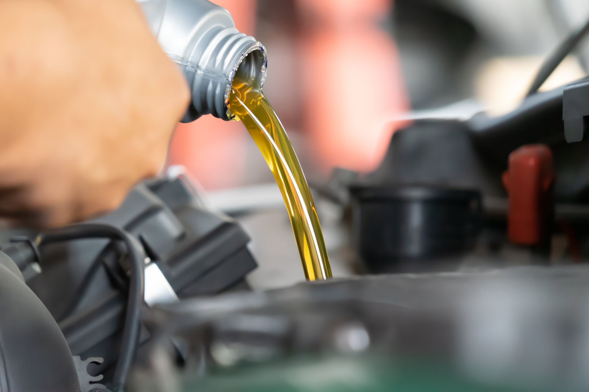 Mechanic pouring engine oil into engine